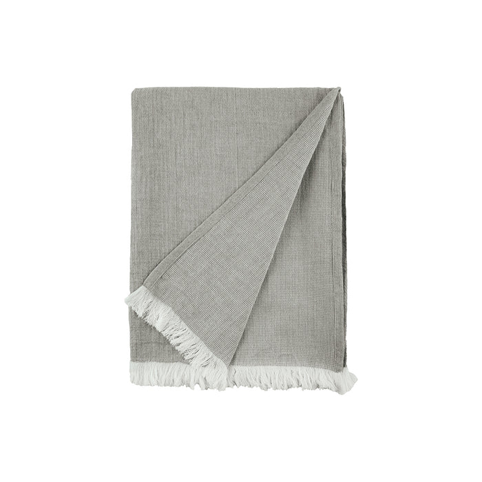 A Declan Ash Bed Throw displayed on a bed.