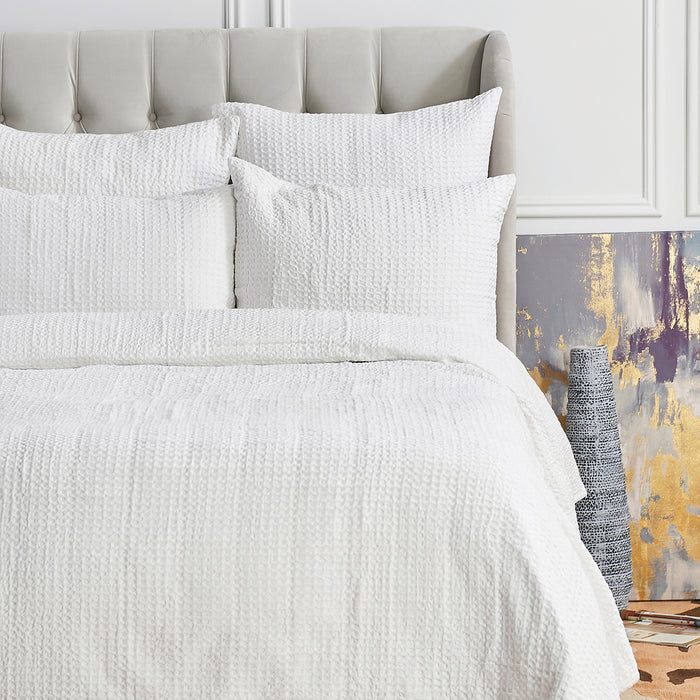 A Waffle Coverlet displayed on a bed.